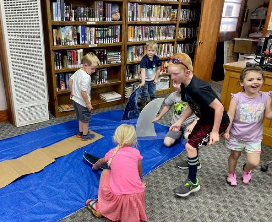 Children walk the plank and avoid the sharks at the Oceans of Possibility summer reading event