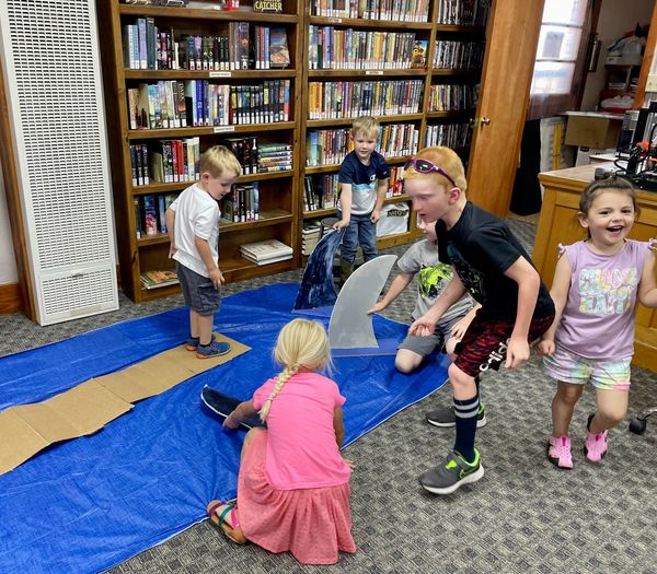 Children walk the plank and avoid the sharks at the Oceans of Possibility summer reading event